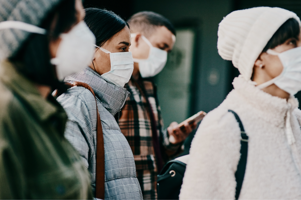 People wearing face masks walking in a public space during the Covid-19 pandemic