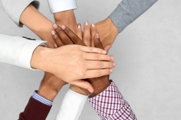 A Diverse team putting their hands together, representing teamwork.